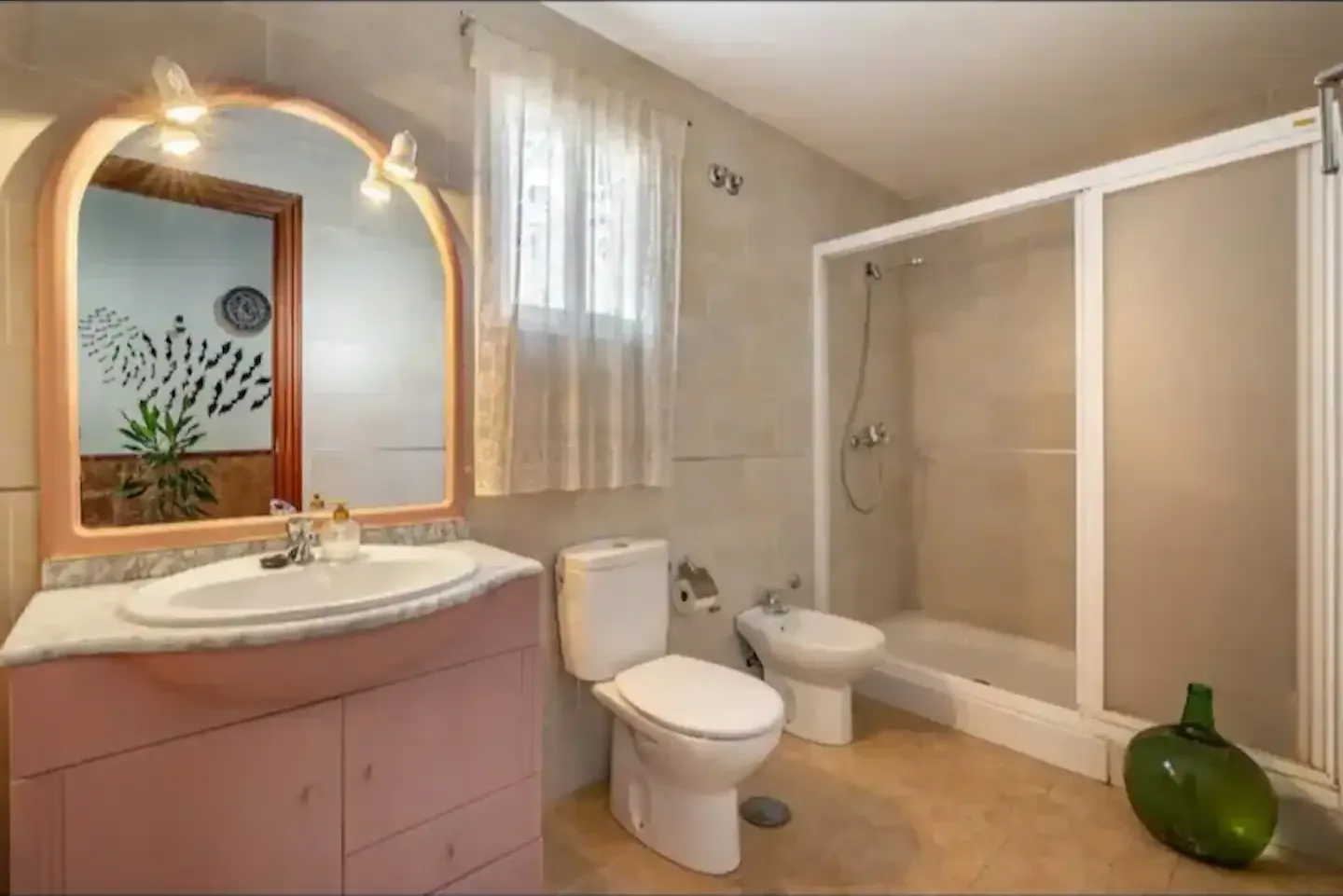 Baño completo con espejo, lavabo, bidé y ducha con mampara