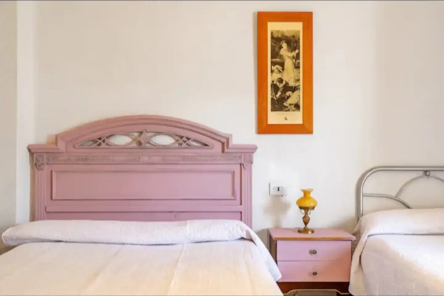 Dormitorio con cabecero rosa y una cama individual junto a la ventana