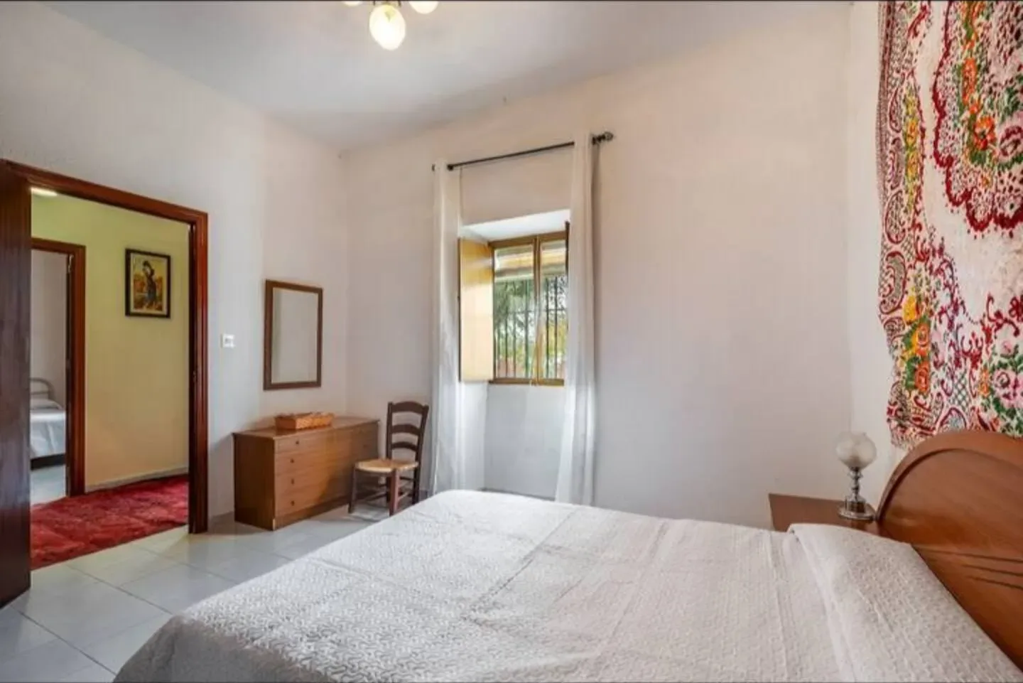 Dormitorio con dos camas y colcha blanca